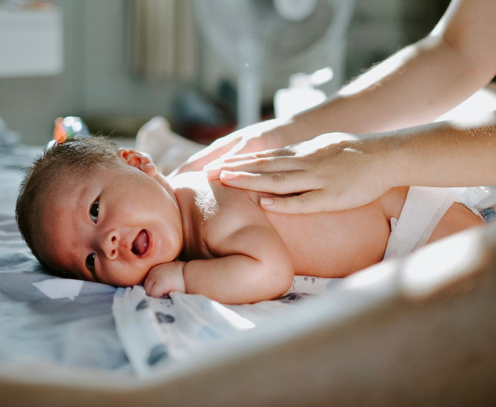 A newborn smiling during an infant massage